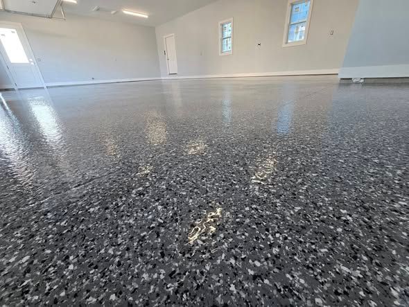 A glossy, speckled gray garage floor. Empty room with windows and a door visible.