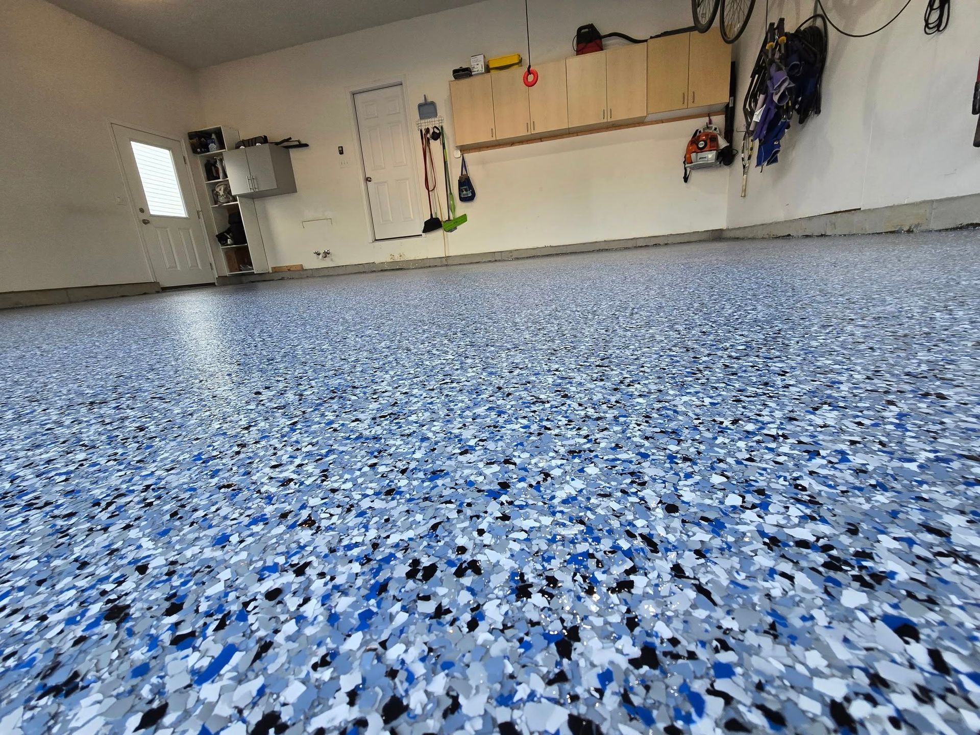 Garage with a blue and gray speckled epoxy floor.