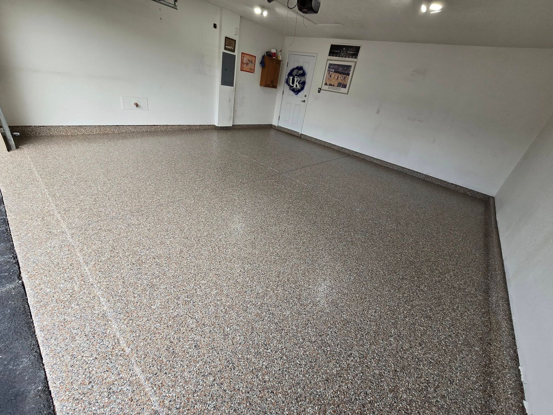 Garage with a speckled epoxy floor and white walls.