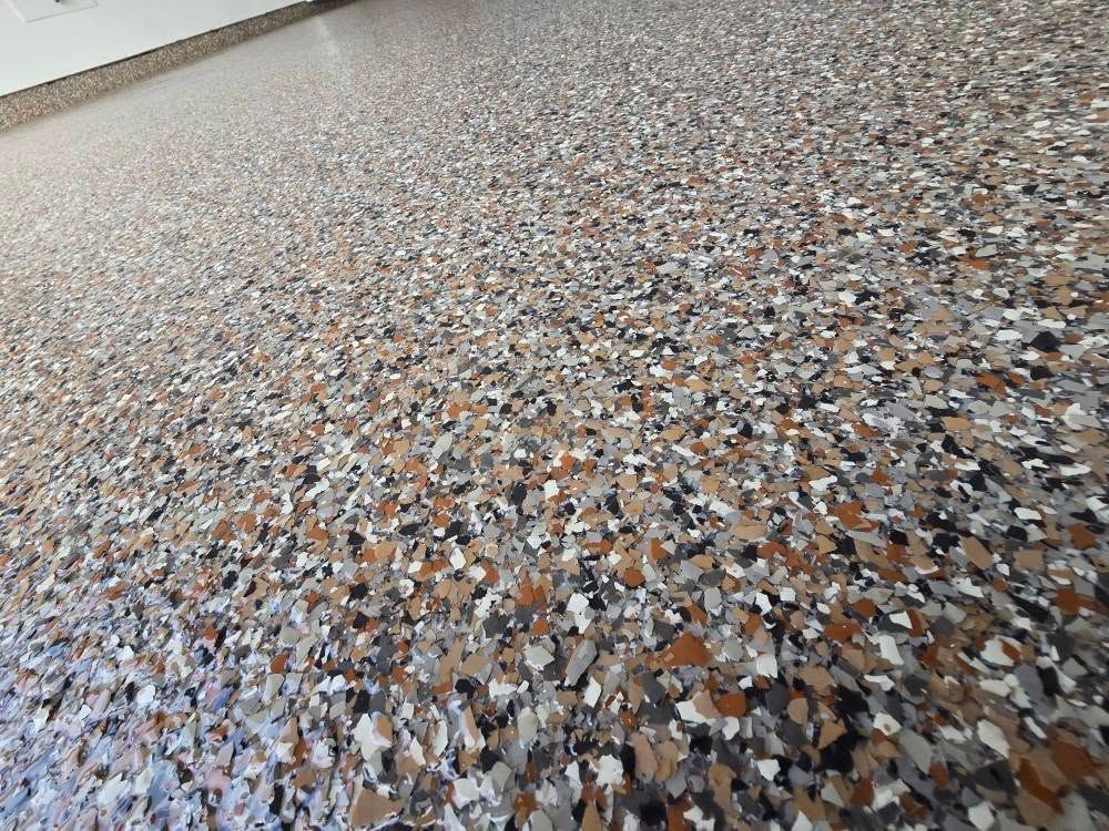 Epoxy garage floor speckled with brown, gray, and white chips.