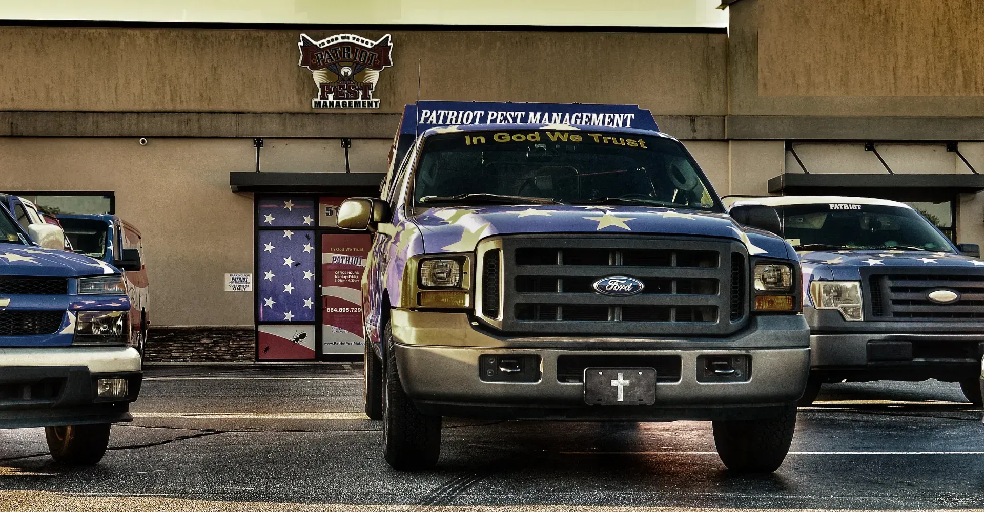 Blue and gold trucks parked in front of a building with an American flag design.
