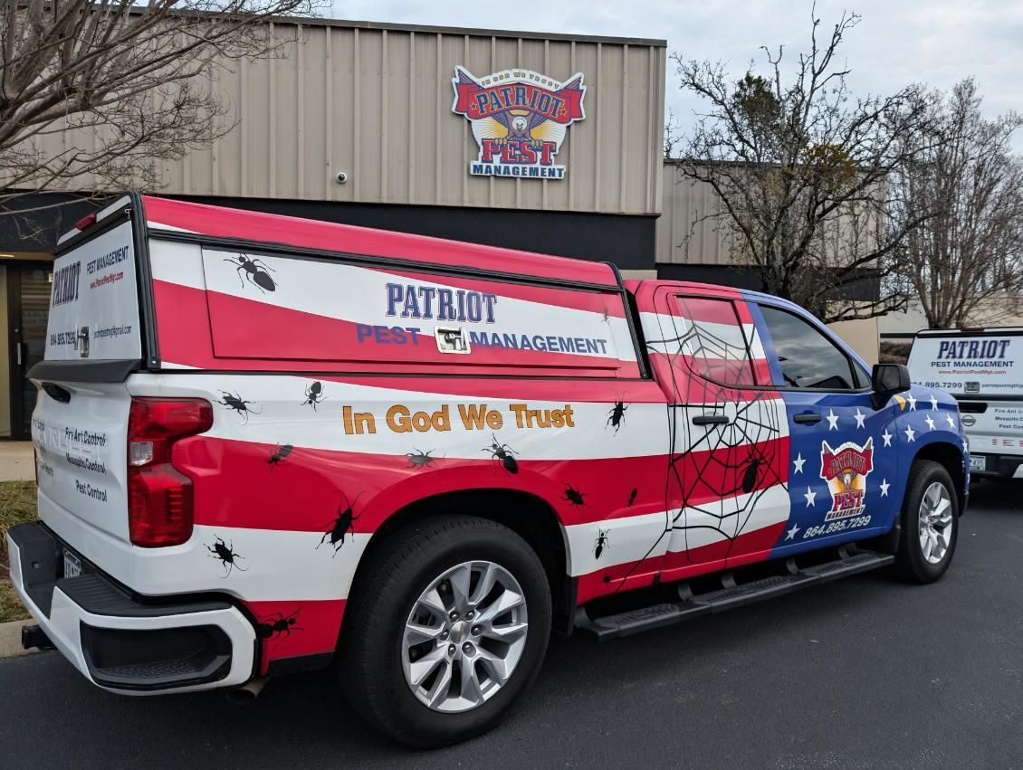 Patriot Pest Management truck with American flag design and company logo parked outside a building.