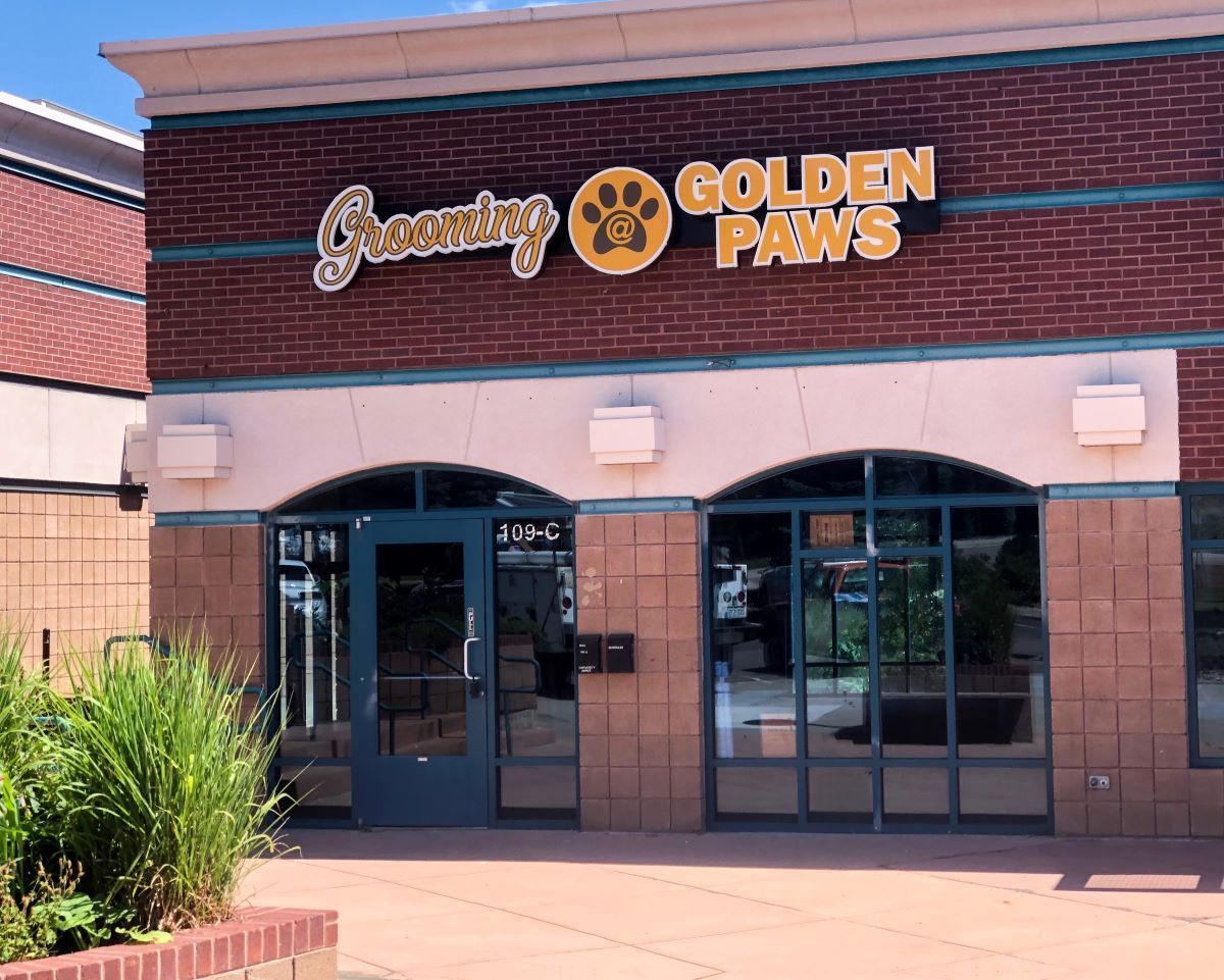 A brick building with a sign that says golden paws