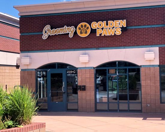 A brick building with a sign that says golden paws