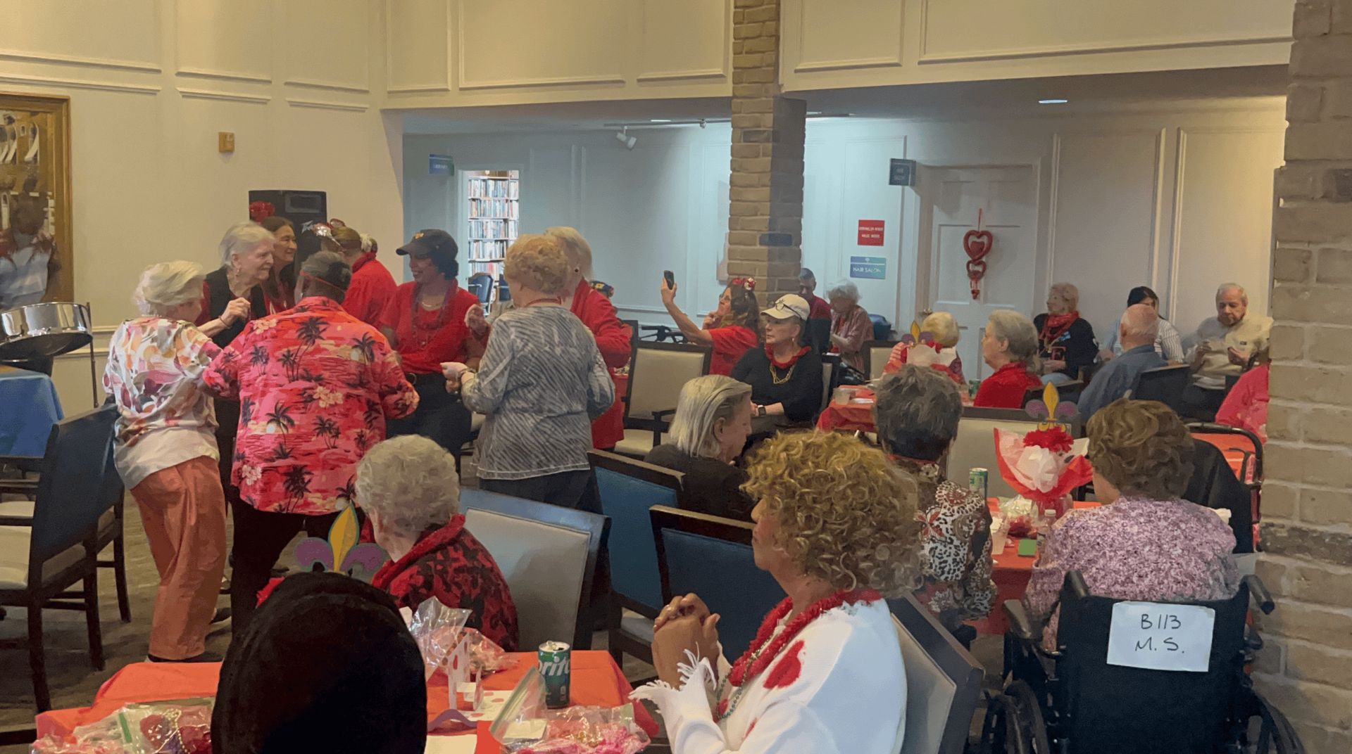 A lively gathering of elderly people in a brightly lit room, engaging in conversation and activities
