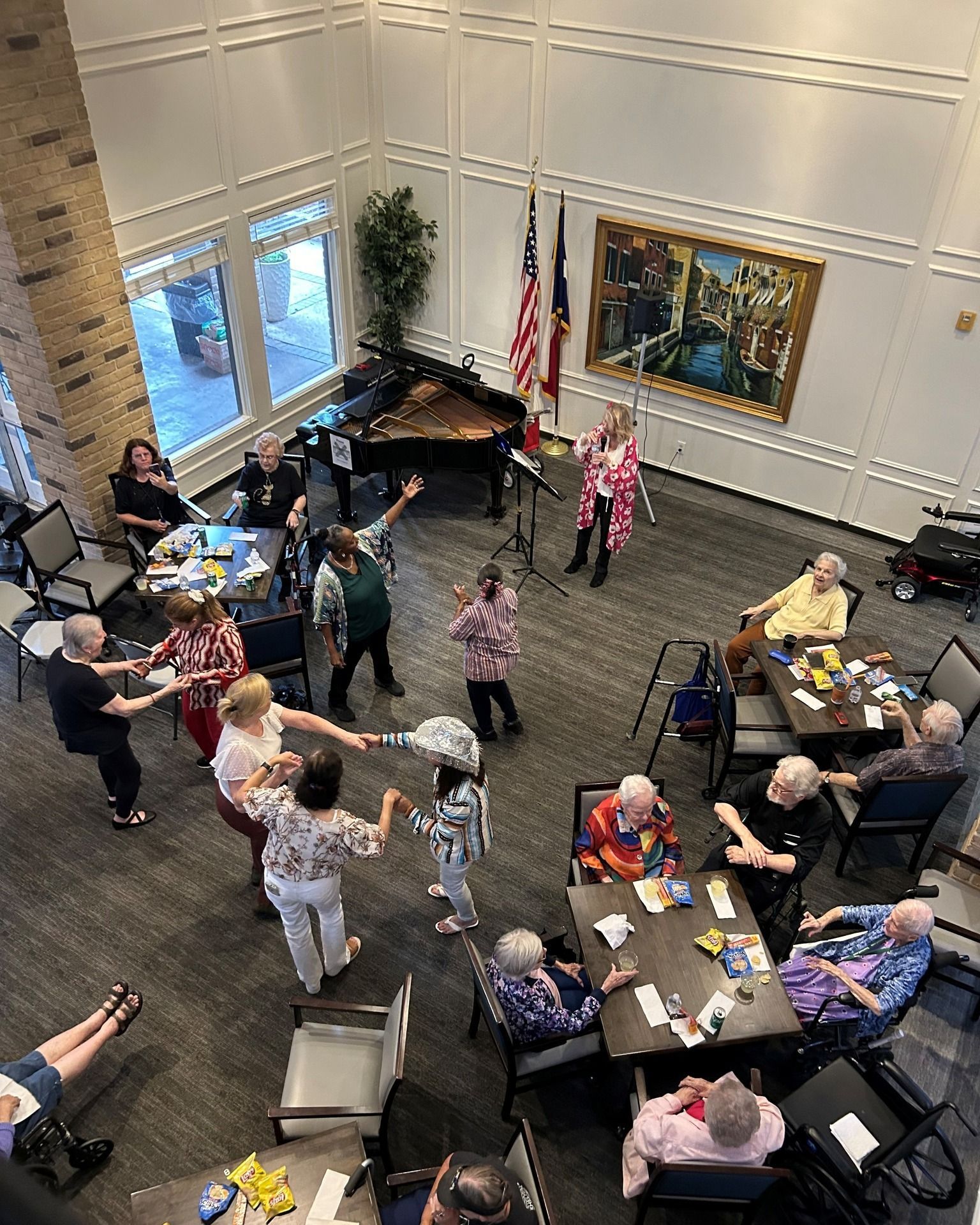 People dancing and listening to music in a large room with a piano.