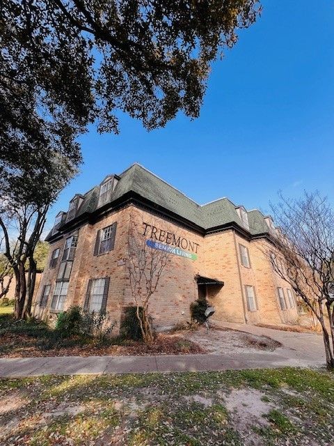 Three-story brick building with a dark roof and 