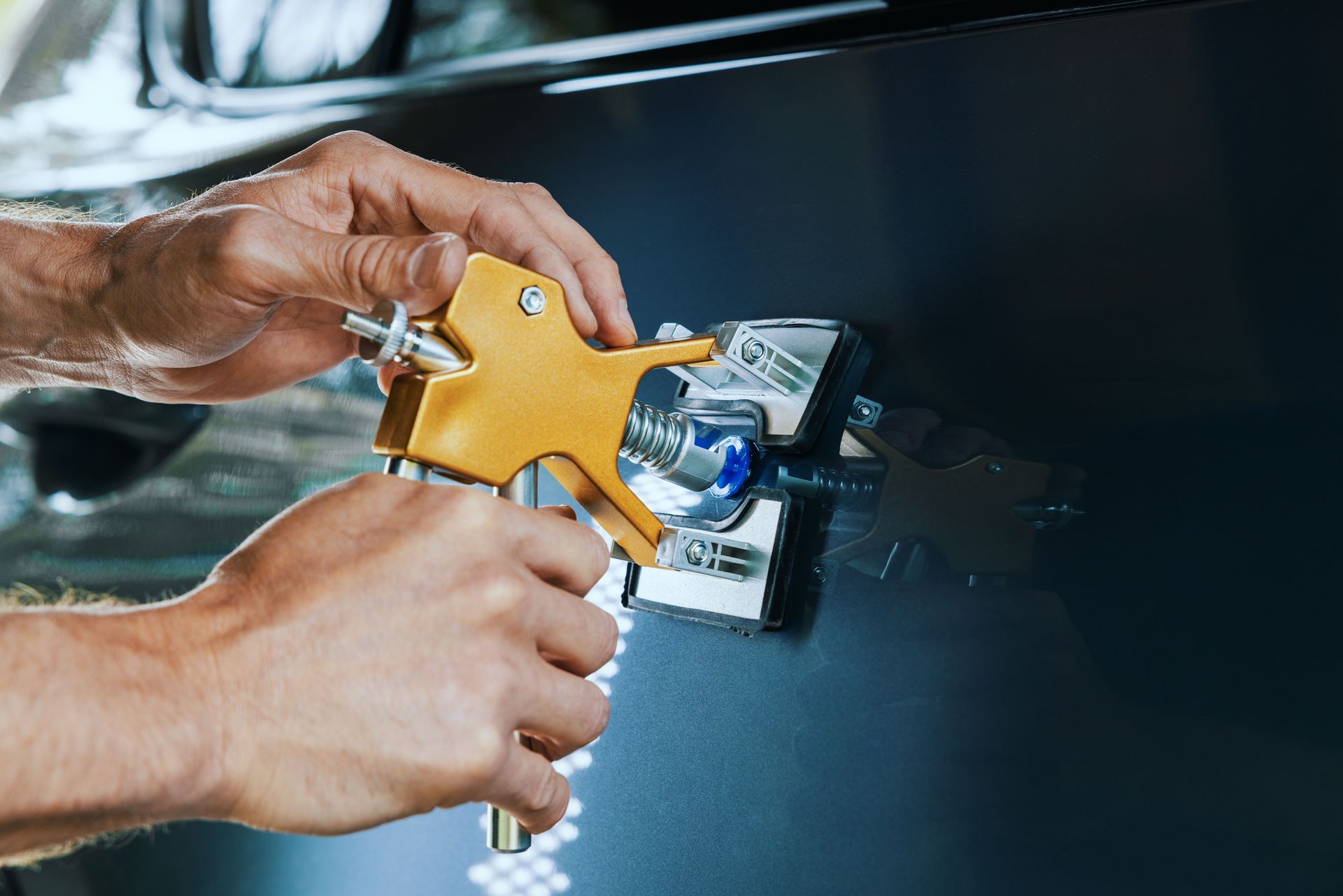 Mechanic inspecting a car bumper in a repair shop.