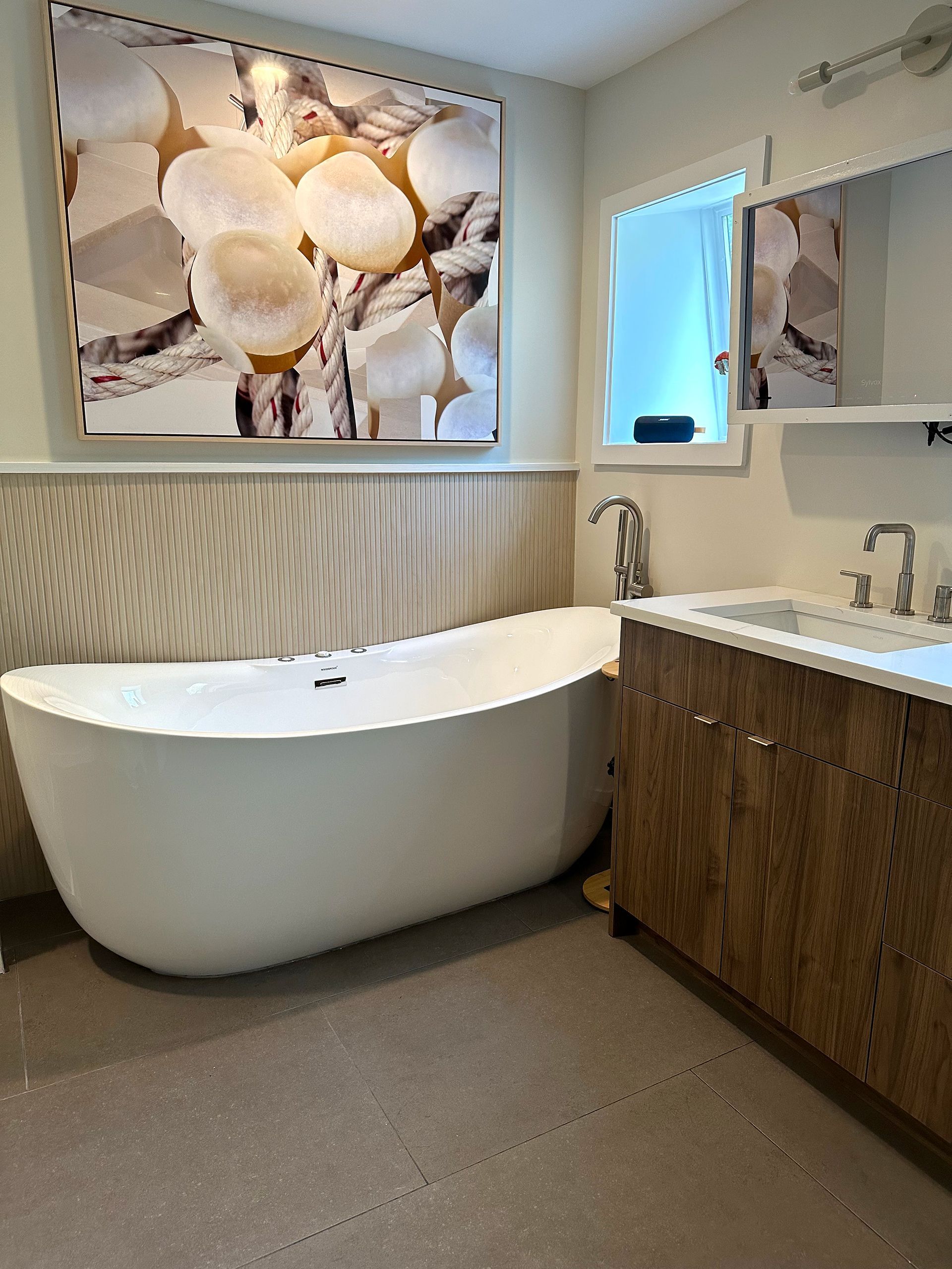 A modern bathroom featuring a white freestanding bathtub