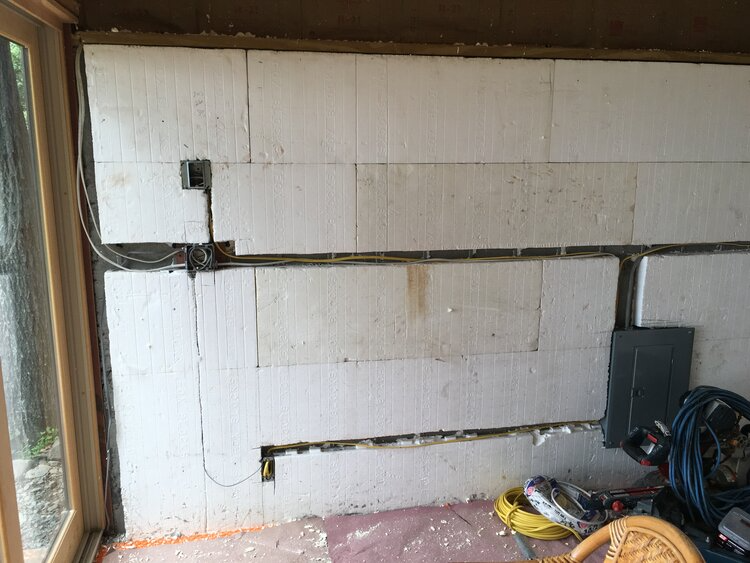 A room with a sliding glass door and a white wall.