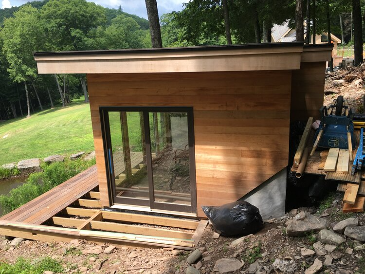 A small wooden house is being built on top of a hill.