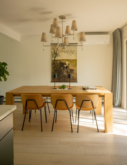 A dining room with a wooden table and chairs