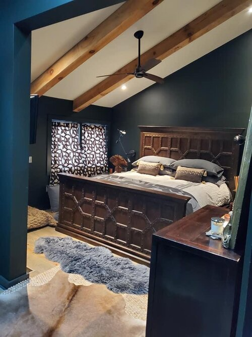 A bedroom with a large bed and a ceiling fan