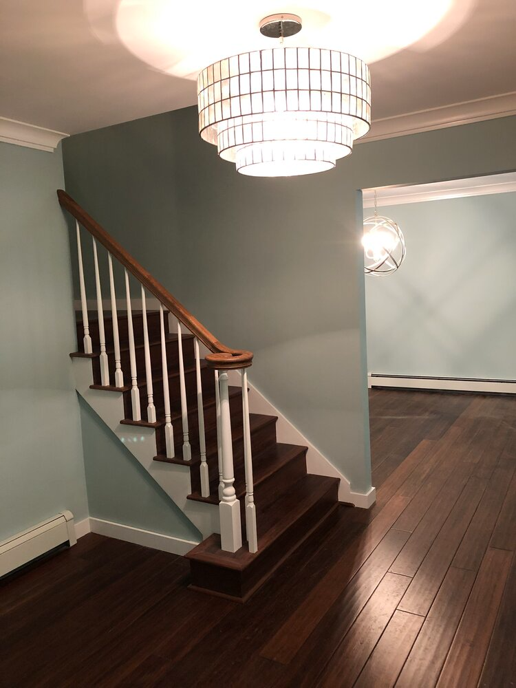 A staircase with a chandelier hanging from the ceiling