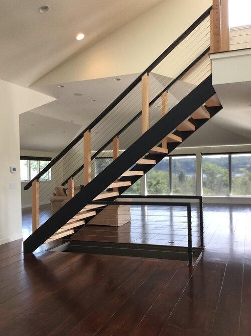 An empty room with a staircase leading up to the second floor