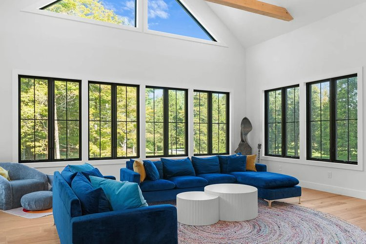 A living room with blue furniture and lots of windows