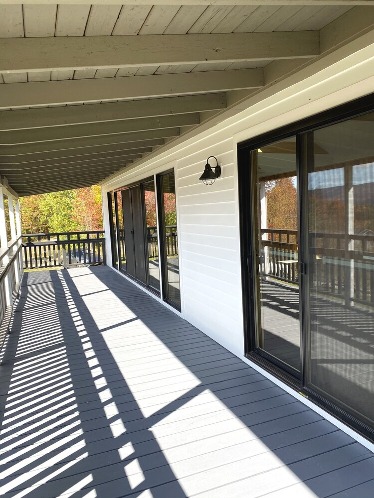 A large porch with sliding glass doors and a railing