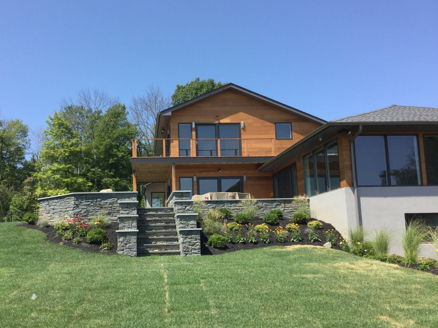 A large house is sitting on top of a lush green hillside.