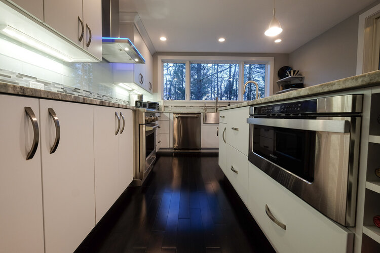 A kitchen with white cabinets and stainless steel appliances