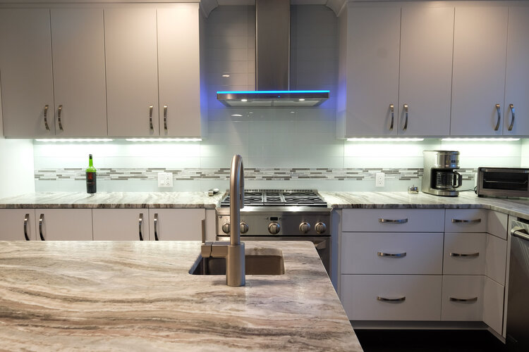 A kitchen with white cabinets and granite counter tops
