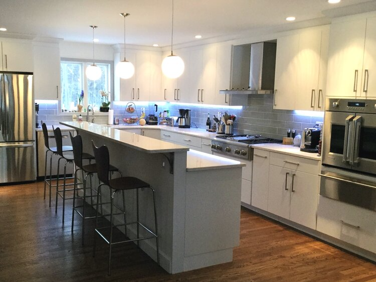 A kitchen with white cabinets and stainless steel appliances