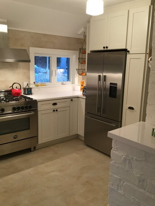 A kitchen with stainless steel appliances and white cabinets
