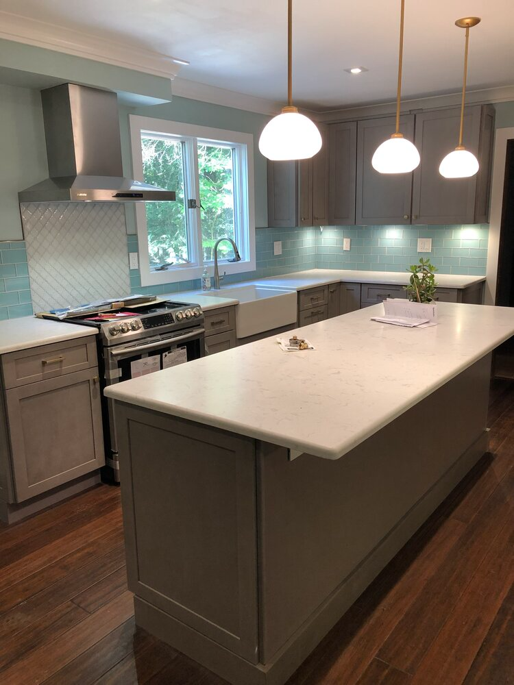 A kitchen with a large island and a stove.