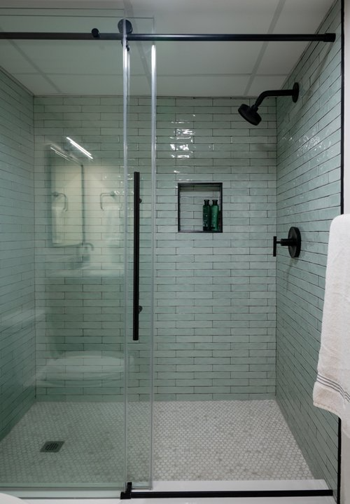 A bathroom with a walk in shower and a sink.