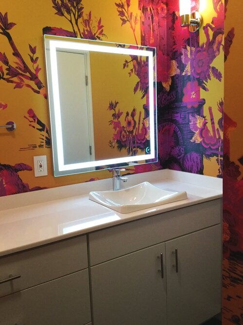 A bathroom with a large mirror and a sink