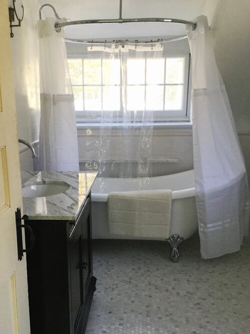 A bathroom with a tub , sink , and shower curtain.