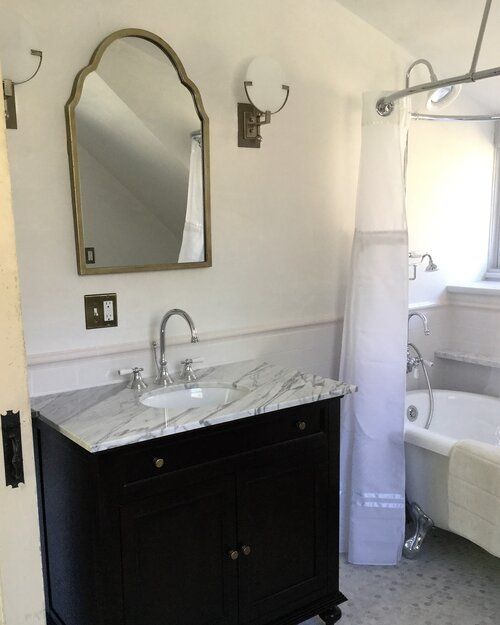 A bathroom with a sink a mirror and a tub