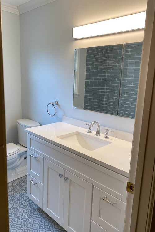 A bathroom with a sink , toilet and mirror.