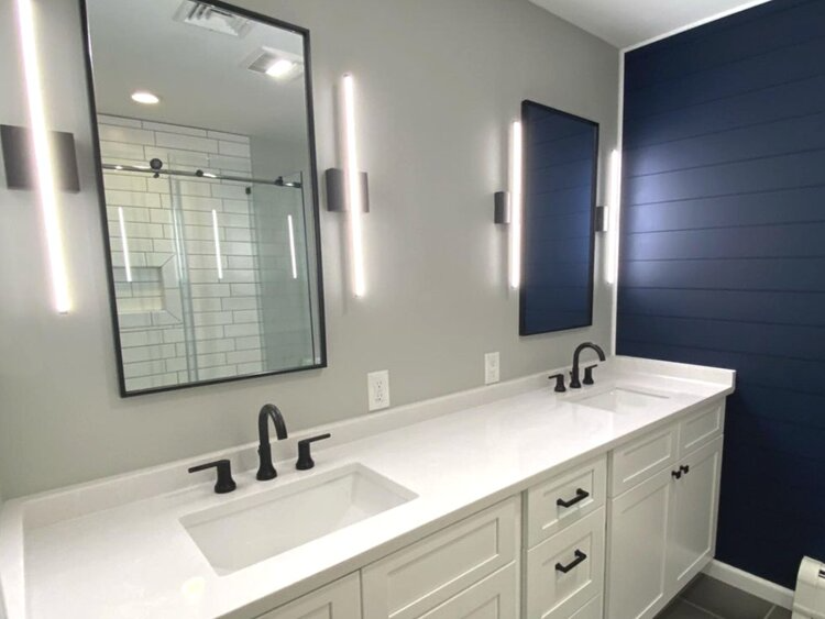 A bathroom with two sinks and two mirrors.