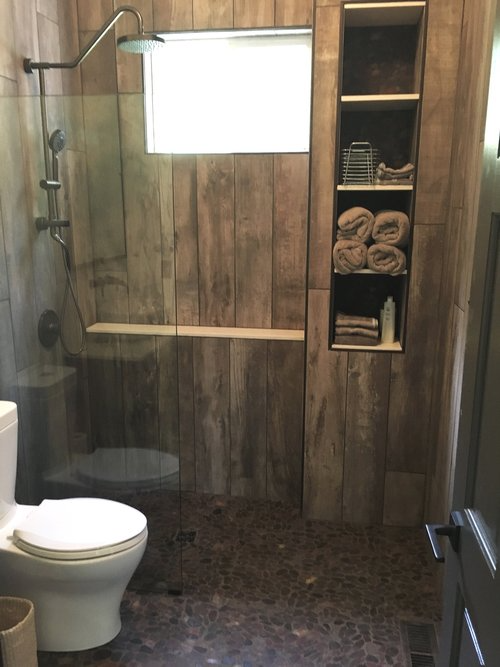 A bathroom with a toilet and a walk in shower