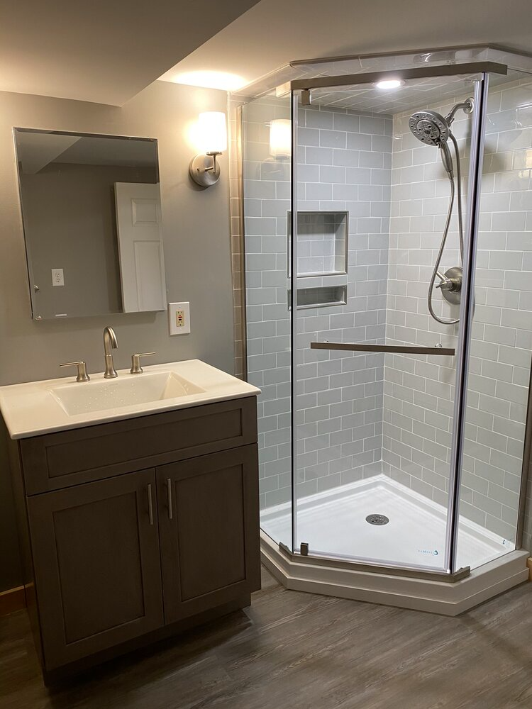 A bathroom with a sink and a walk in shower.