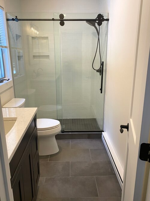 A bathroom with a toilet , sink , and shower.