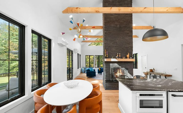 A kitchen with a table and chairs and a fireplace.