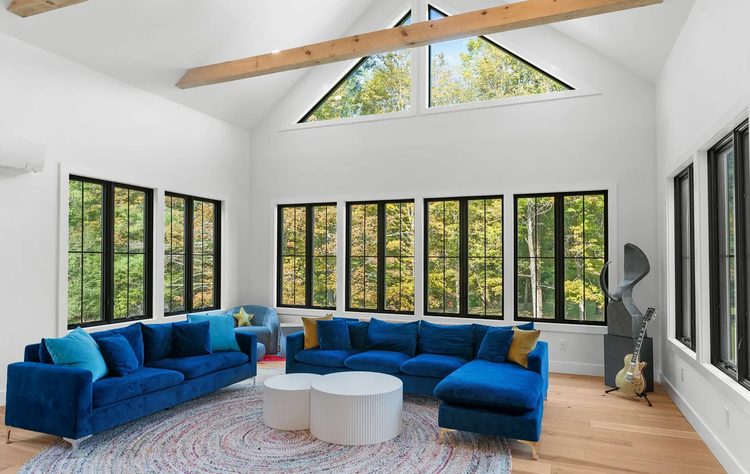 A living room with blue couches and a lot of windows