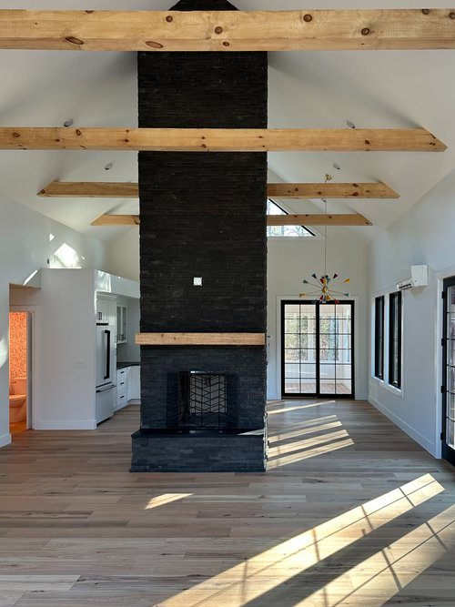 A living room with a fireplace and wooden beams