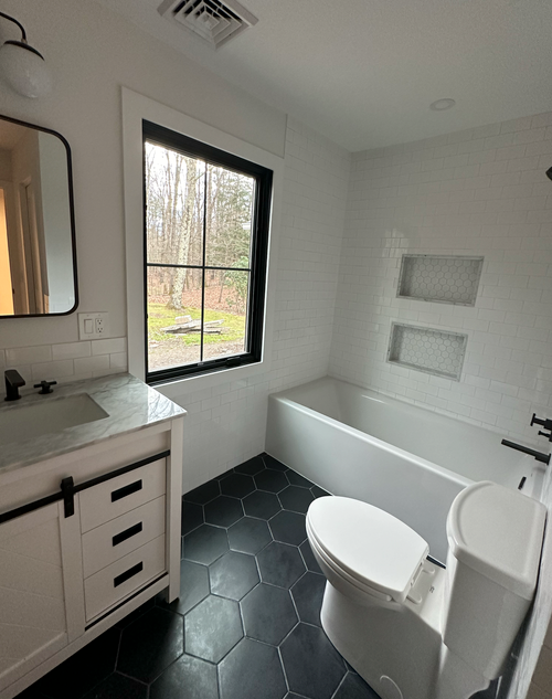 A bathroom with a toilet , sink and bathtub