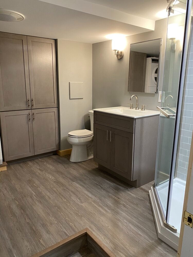 A bathroom with a toilet , sink , and shower.