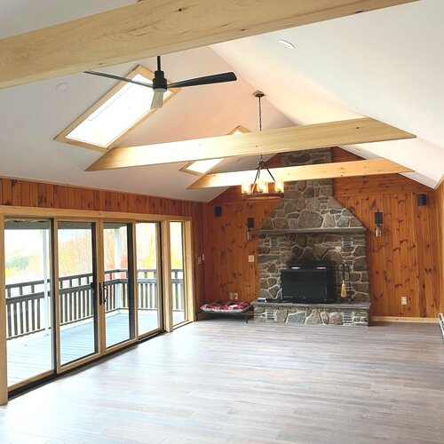 A living room with a fireplace and a ceiling fan