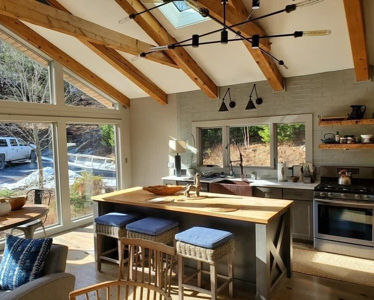 A kitchen with a large island in the middle and a lot of windows