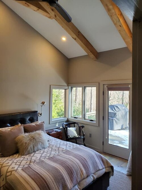 A bedroom with a bed and a ceiling fan