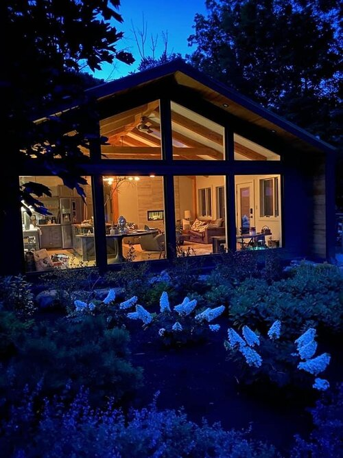 A house with a lot of windows is lit up at night