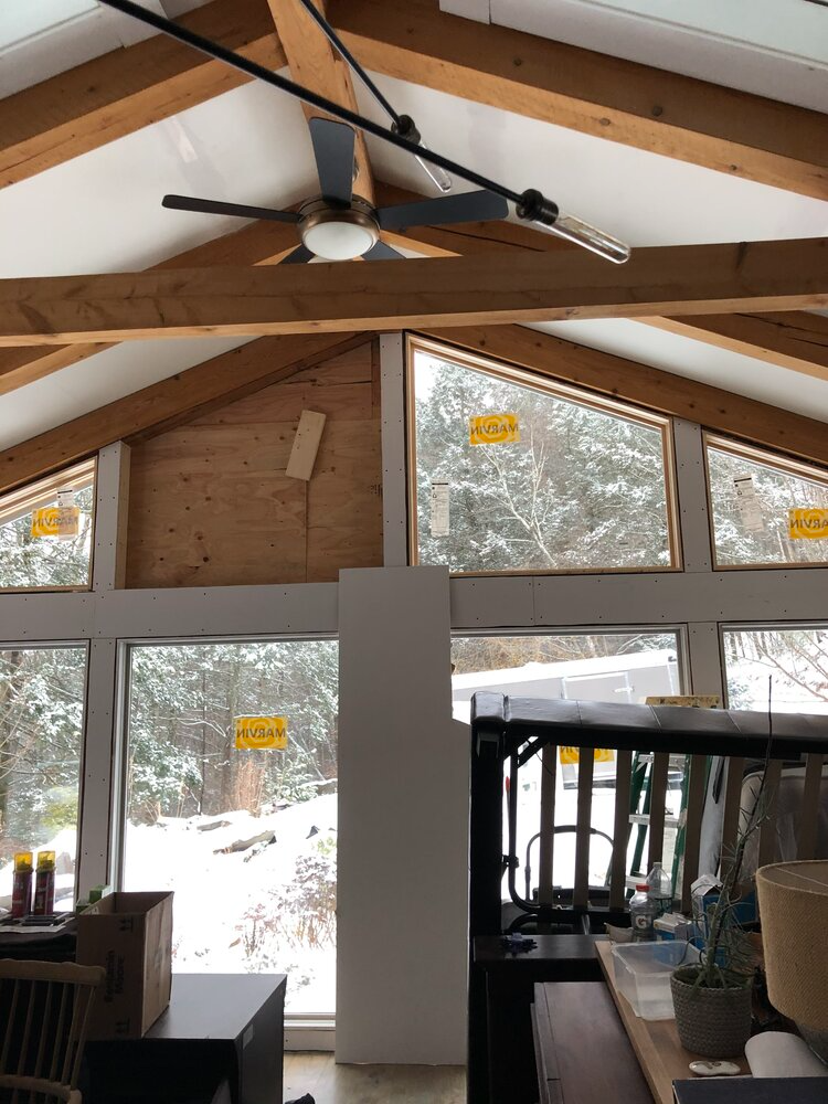 A room with a lot of windows and a ceiling fan
