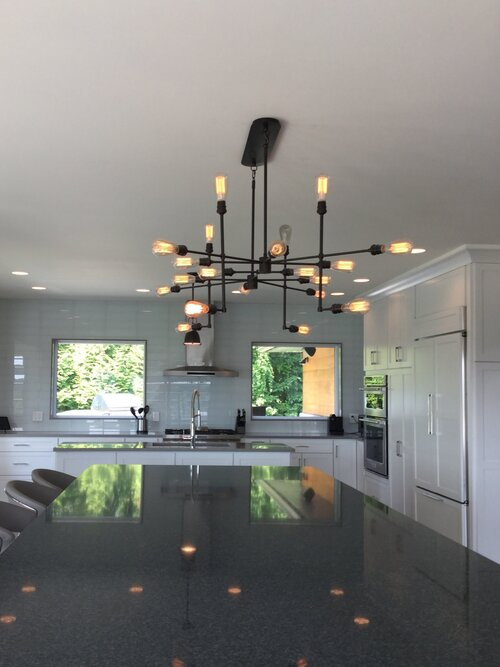 A kitchen with a large chandelier hanging from the ceiling