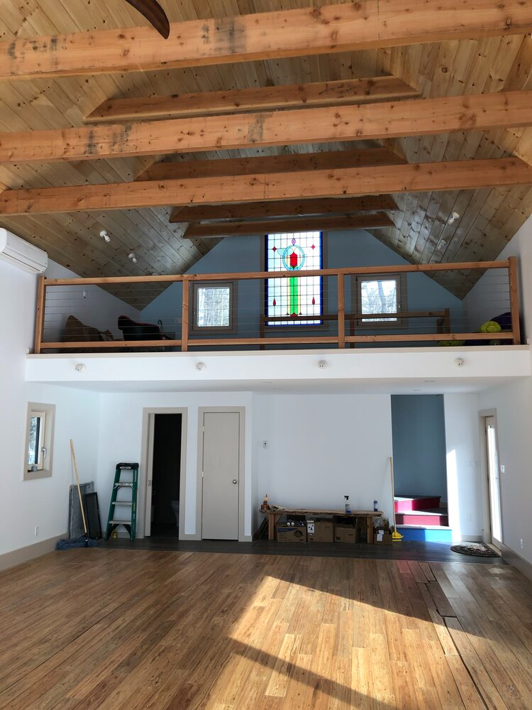 An empty room with a balcony and a stained glass window