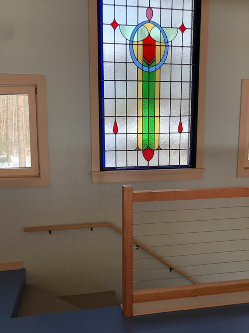 A staircase with a stained glass window above it