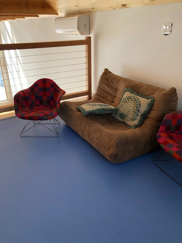 A living room with a couch and two chairs